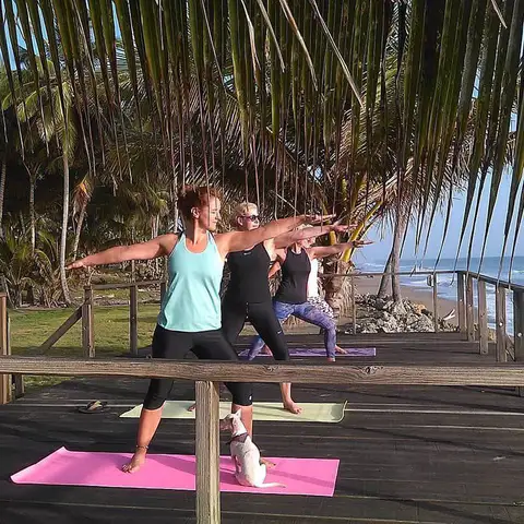 Instructor guiding a warrior pose on the deck