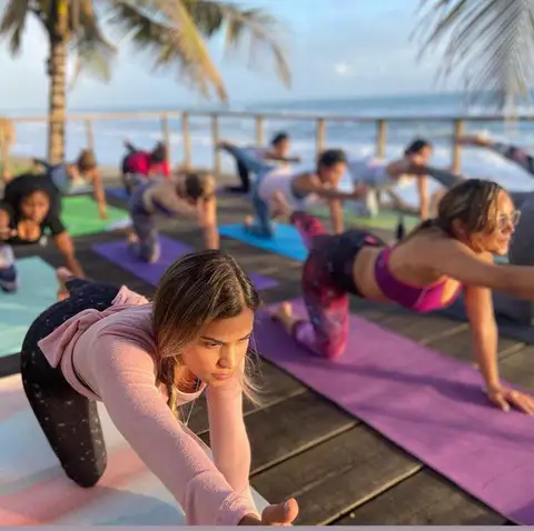 Women stretching on yoga mats on the wooden deck