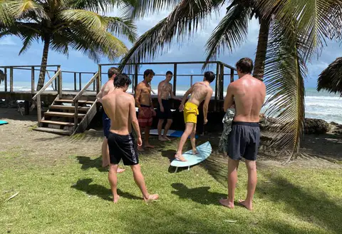 Surfers gathering by the ocean deck with their boards