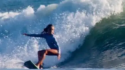 Surfer carving through a breaking wave