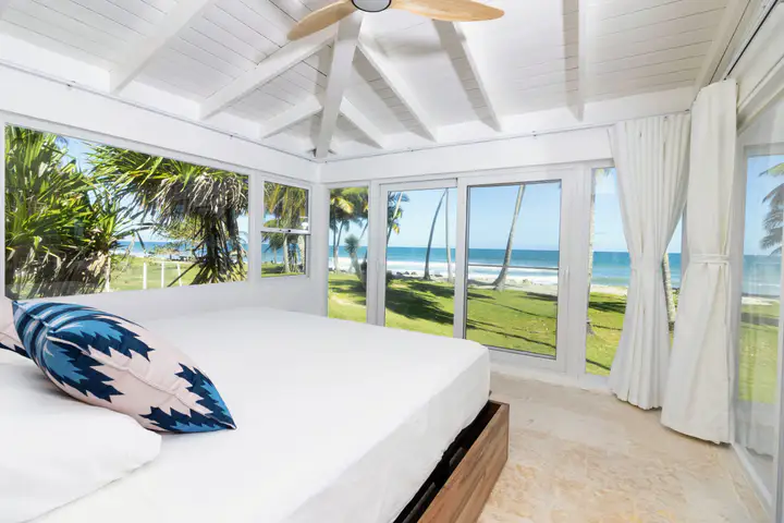 Villa master bedroom with ocean view through floor to ceiling windows