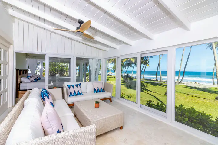 Villa sunroom with white wicker sofas and ocean views