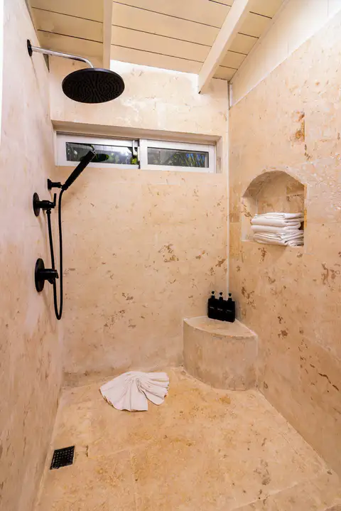 Stone shower with a niche and black fixtures