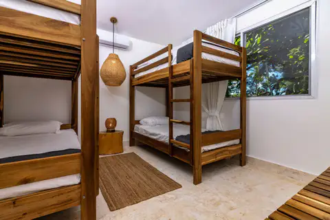Bunk bed room in a poolside suite with a woven pendant lamp