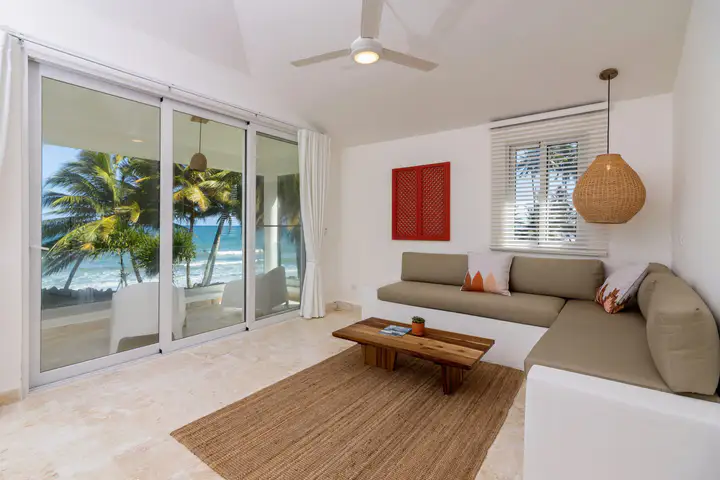 Bright suite living room with ocean view through sliding glass doors