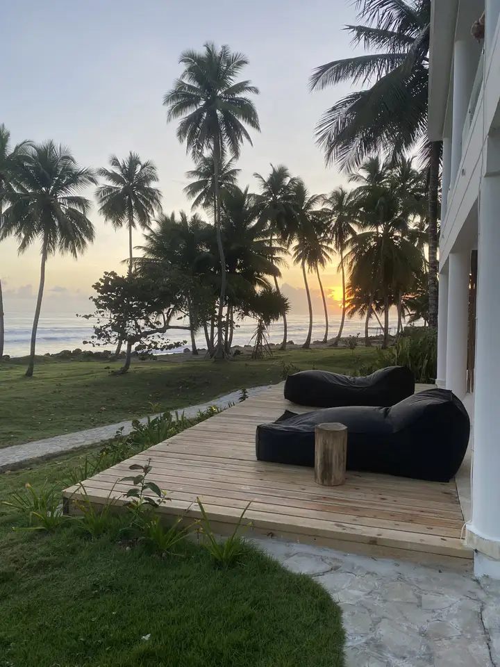 Wooden deck with lounge beds at sunset in front of the beachfront suites