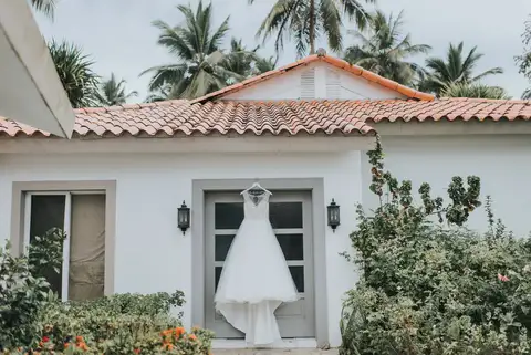 Bridal villa with a red tile roof and the wedding dress hanging in the doorway