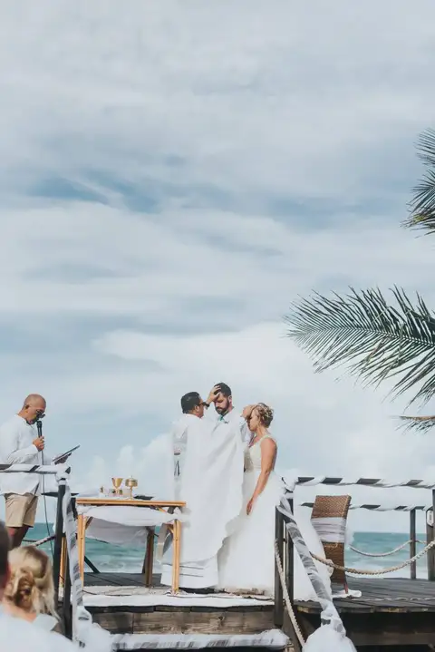 Wedding ceremony on the ocean deck under a cloudy sky