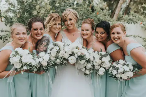 Bride with her bridesmaids holding white bouquets