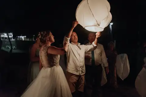 Couple releasing a paper lantern at night