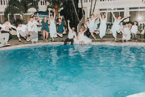 Wedding guests jumping into the pool