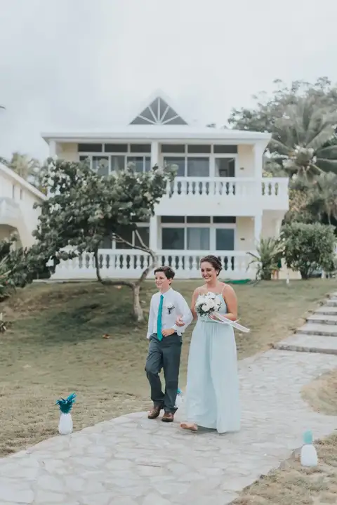 Couple walking down the stone path toward the white beachfront building