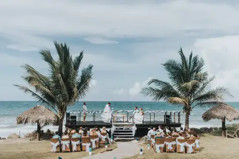 Ceremony seating arranged on the beach in front of the deck