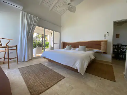 Villa bedroom with a wooden bed and balcony doors