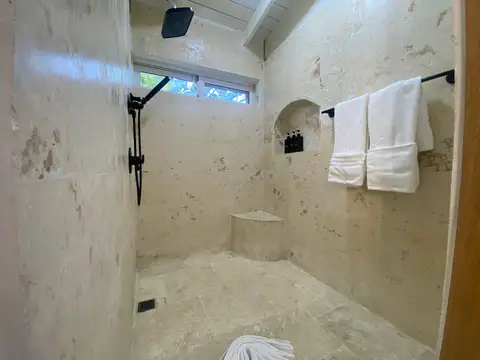Stone walk in shower with folded towels