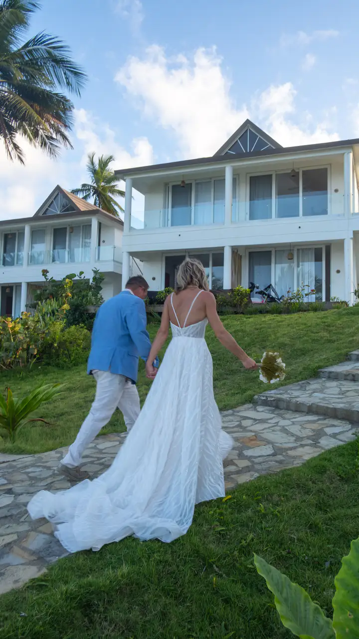Bride standing beside a white beachfront building