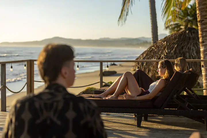 Guest relaxing on a black daybed on the ocean deck