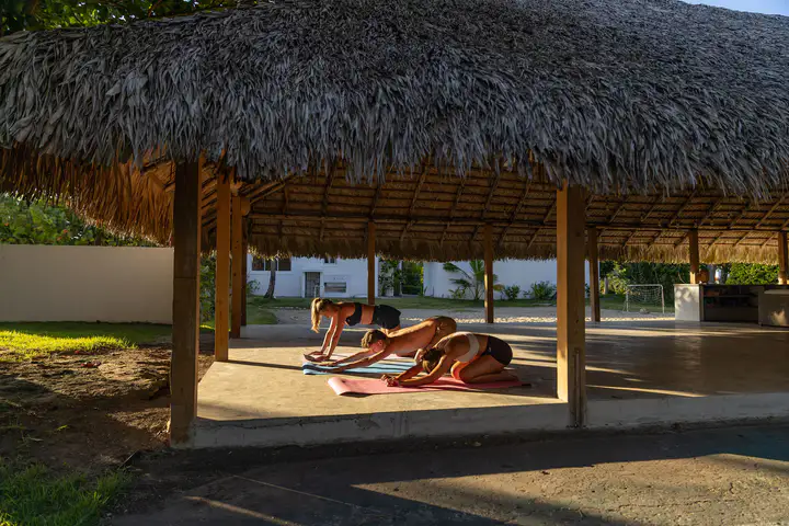 Guests practicing yoga beneath the open air palapa