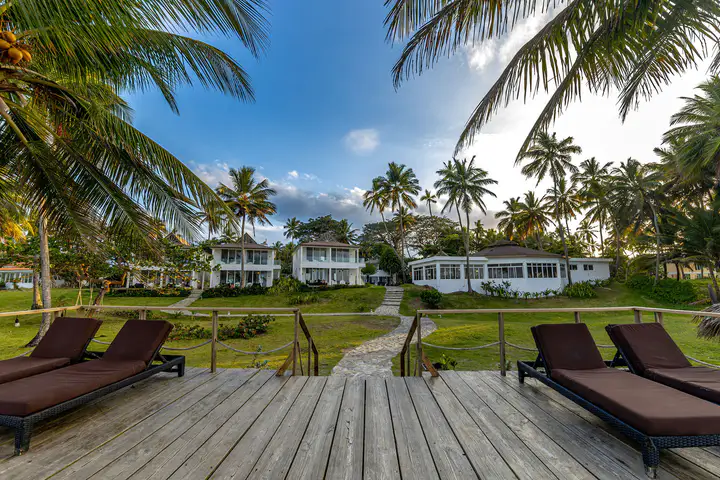Beachfront suites and palms seen from the ocean deck